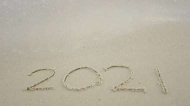 4K Mutlu Yeni Yıl 2022. 2022. Kumlu plajda yazın, okyanus dalgası 2022 'ye sıçradı. Mutlu yıllar için 2021' den 2022 'ye geri sayım başladı.