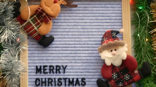 给梅里 克里斯提斯写信 写在写字板上 桌上摆放着圣诞老人和驯鹿娃娃 圣诞装饰品 毛皮装饰和闪光的灯光 圣诞和节日的问候背景 — 图库视频影像