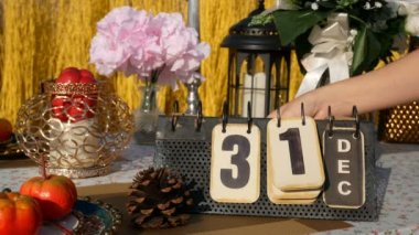 4 bin. 31 Aralık 'tan 1 Ocak' a kadar değişen el yapımı metal takviminin sayfasını parti dekorasyonuyla birlikte masaya çevirin. Yeni yıl konsepti için geri sayım
