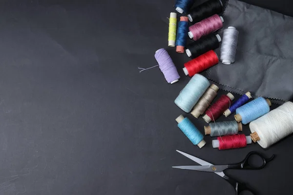 Colored threads and needles. Everything you need for sewing. Several spools of thread. Sharp needles.Red, black, gray and blue thread coils isolated on white background