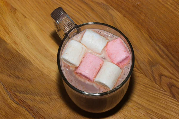 Marshmallowlu sıcak ve lezzetli kakao ve şekerli kekler. Sonbahar içkisi sıcak battaniyeler, koniler, meşe palamutları ve sarı yapraklar arasında