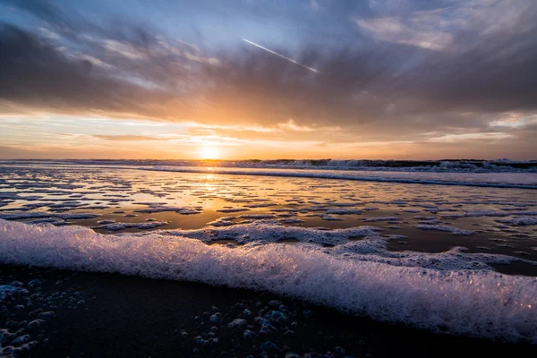 Solnedgång och vatten eftertanke på stranden — Stockfoto