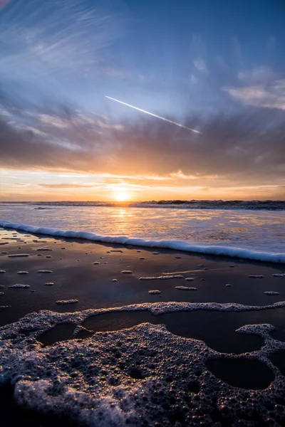 Solnedgång och vatten eftertanke på stranden — Stockfoto