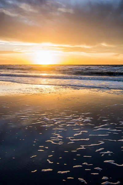 Sunset and water reflection on beach — Stock Photo, Image