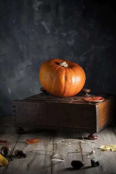 木製のテーブルの上にオレンジカボチャと古い棺 — ストック写真