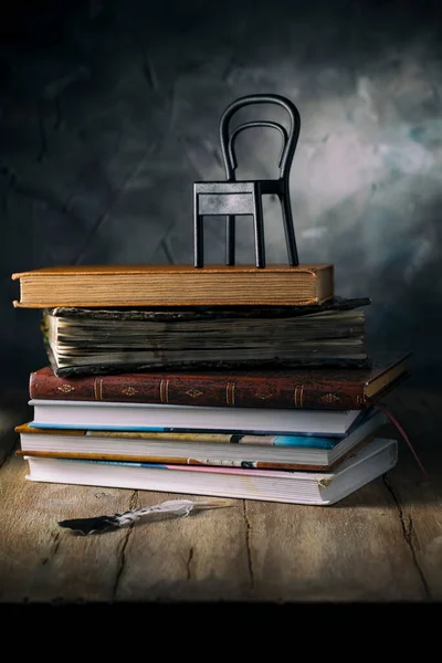 Μια Στοίβα Βιβλία Και Μια Μικρή Καρέκλα Ένα Ξύλινο Τραπέζι — Φωτογραφία Αρχείου