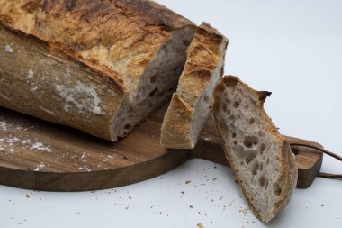 Taze dilimlenmiş beyaz ekmek ve beyaz arka planda kesim tahtası