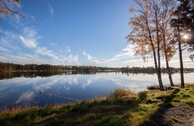 Göl kıyısı ve mavi gökyüzü Sonbahar güneşli bir günde