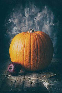 Masada büyük portakal kabağı ve elma var.