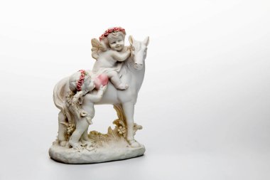 Beyaz atın seramik heykelciği ve iki küçük melek.