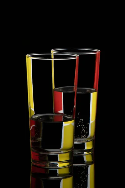Two Glass Glasses Colored Highlights Black Background — ストック写真