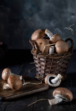 Basket with champignons on a wooden table