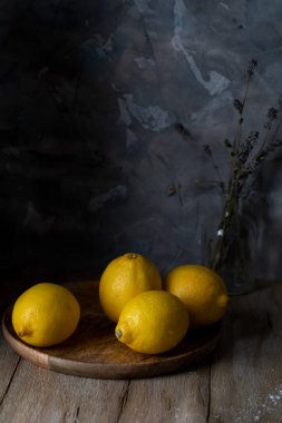 Kırsal bir masada ahşap bir bardakta limonlar