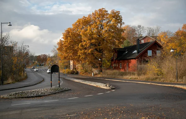 Gustavsberg. Fork in the road and a red wooden house on an autumn day against the sky