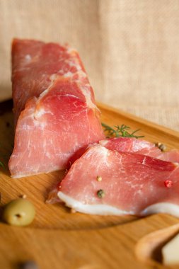 Tahtada kurutulmuş domuz filetosu peynir, zeytin, karabiber ve domates sosuyla servis ediliyor. Kurutulmuş fileto aperatifi. Belarus mutfağı tabağı. Yüksek kalite fotoğraf