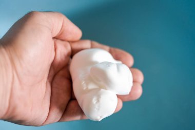 Bir adamın elindeki köpüğü traş et.