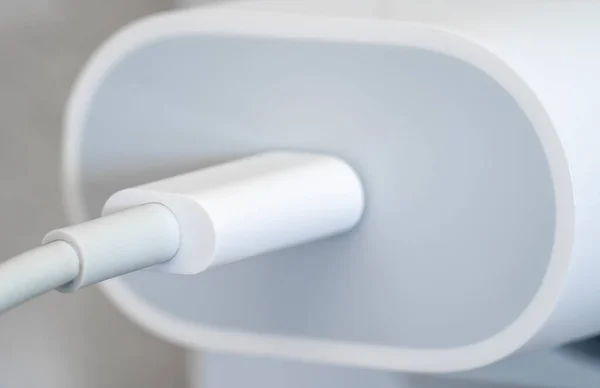 Makro kabloyla duvara takılmış bir cep telefonu şarj cihazını kapat