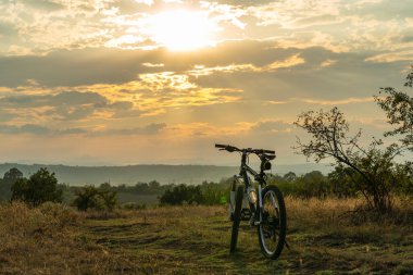 Bicycle on a mountain trail at sunset in nature