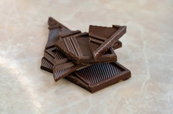Шматочки шоколадного бару на мармуровому столі Стокова Картинка