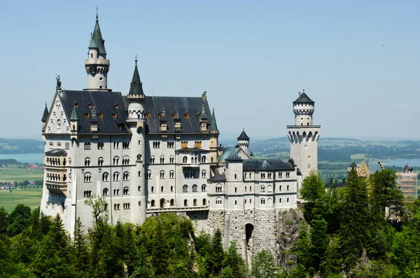 Fussen, Jerman - 29 Juni 2019: Kastil Neuschwanstein diselimuti kabut di Pegunungan Alpen Bayern. Stok Foto Bebas Royalti