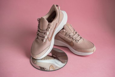 Kyiv, Ukrayna - 13 Temmuz 2020: Pembe arka planda yuvarlak aynalı Nike koşu ayakkabıları
