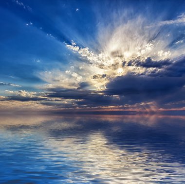 Denizde güzel bulutlu gün batımı