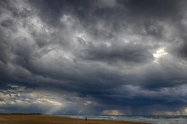 HDR puesta de sol Rayos de sol a través de las nubes en una playa de invierno — Foto de Stock