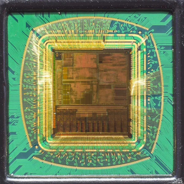 Chip de computador aberto com conexões de fio de ouro em comparação com uma agulha — Fotografia de Stock