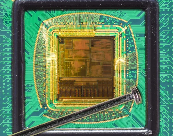 Offener Computerchip mit Golddraht-Anschlüssen im Vergleich zu einer Nadel — Stockfoto