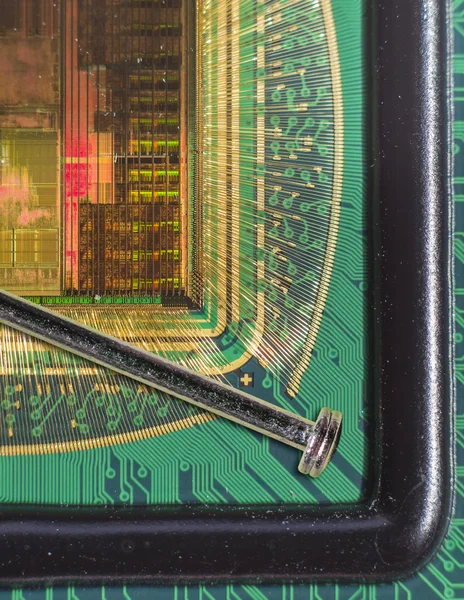 Відкритий чип комп'ютера з з'єднаннями із золотим дротом у порівнянні з голкою — стокове фото