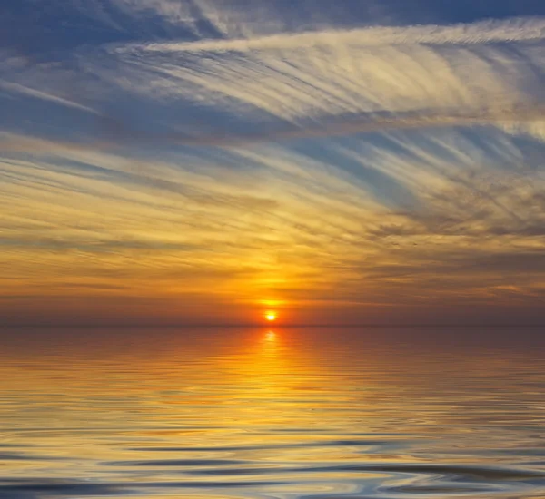 Vackra molnigt solnedgång vid havet Stockfoto