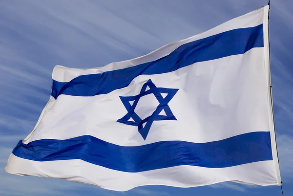 Israël vlag in de wind geïsoleerd tegen de hemel fladderende Rechtenvrije Stockafbeeldingen
