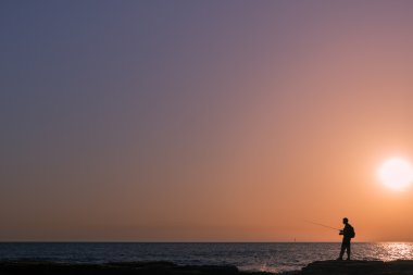 gün batımında balıkçılık siluet