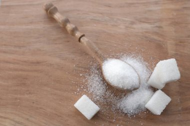 kristal granüle şeker tanecikleri ve beyaz şeker küpü arka planı masanın üzerinde