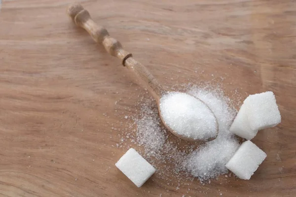 kristal granüle şeker tanecikleri ve beyaz şeker küpü arka planı masanın üzerinde