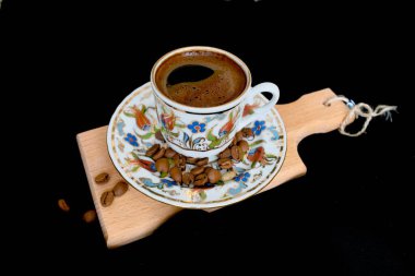 Siyah arka planda bir fincan sıcak kahve.