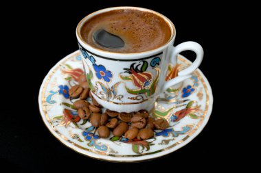 Siyah arka planda bir fincan sıcak kahve.