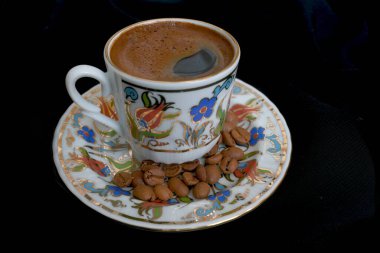 Siyah arka planda bir fincan sıcak kahve.