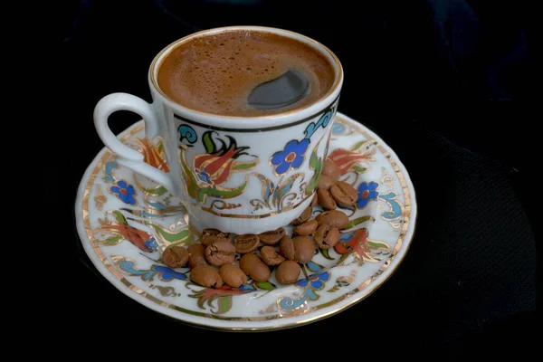 Siyah arka planda bir fincan sıcak kahve.