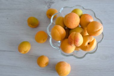 Apricot fruit background in a bowl on wooden table