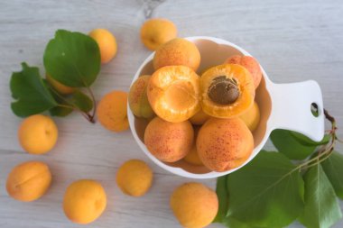Apricot fruit background in a bowl on wooden table