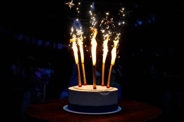 Koyu arkaplanda havai fişekli pasta.