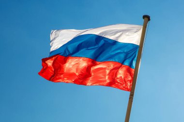 Mavi gökyüzüne karşı dalgalanan Rus bayrağı