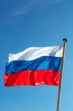 Mavi gökyüzüne karşı dalgalanan Rus bayrağı