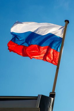 Mavi gökyüzüne karşı dalgalanan Rus bayrağı