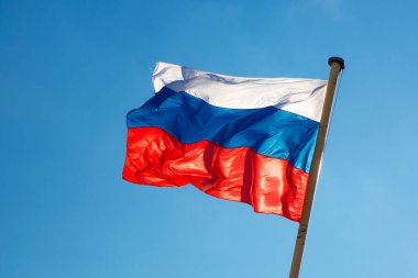 Mavi gökyüzüne karşı dalgalanan Rus bayrağı