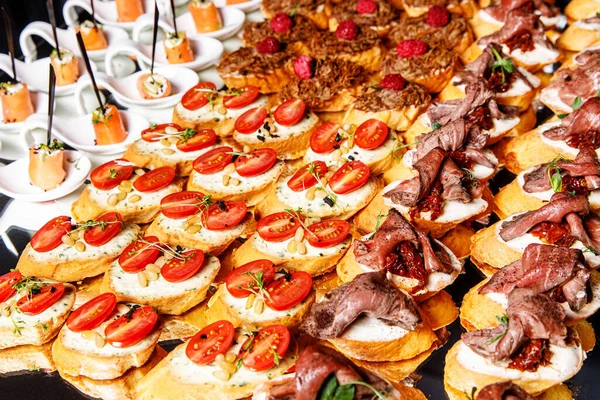 Yemek büfesi. Sebzeli soğuk aperatifler, balık ve ekmek üzerine roka, kanepeler.