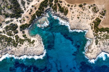 Güzel bir deniz limanının manzarası. Turkuaz suyu olan bir göl. Kayalık kıyılara yakın dalgalar