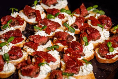 Siyah tepside et bruschetta. Baget ekmeğinde sığır eti ve kurutulmuş domates.