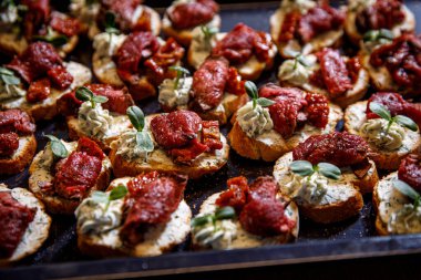 Siyah tepside et bruschetta. Baget ekmeğinde sığır eti ve kurutulmuş domates.